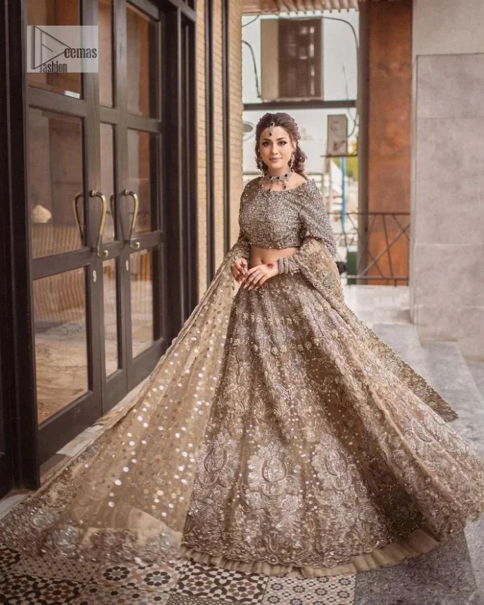 A dreamy statement of brown nikah outfit! This dress proffers a brown hue with its glamorous silver embroidery. The handsome and attractive embellishments include tilla, dabka, kora, Kundan and the real magic of Zardozi. The blouse has a boat-shaped neckline to enhance the features. Further, the floral patterns on full sleeves make this outfit more lovely. It is paired up with meticulously handcrafted lehnga which is bold enough to stand out in the crowd. Complete this article with a scalloped dupatta in the same colour framed with a four-sided border and sequin sprayed all over to make it dreamy.