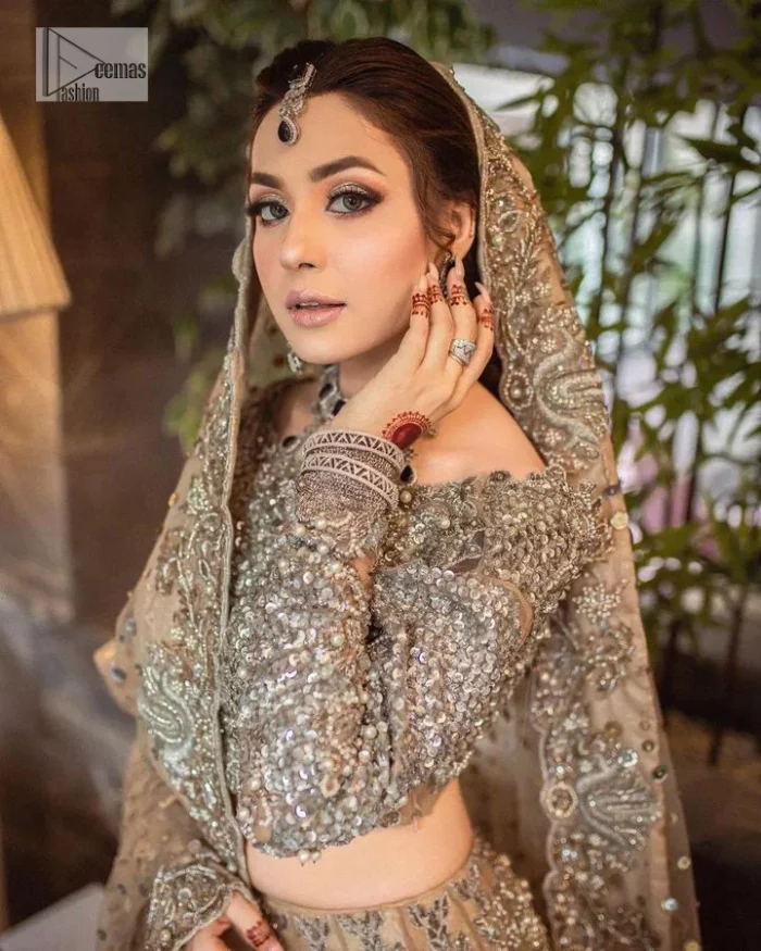 A dreamy statement of brown nikah outfit! This dress proffers a brown hue with its glamorous silver embroidery. The handsome and attractive embellishments include tilla, dabka, kora, Kundan and the real magic of Zardozi. The blouse has a boat-shaped neckline to enhance the features. Further, the floral patterns on full sleeves make this outfit more lovely. It is paired up with meticulously handcrafted lehnga which is bold enough to stand out in the crowd. Complete this article with a scalloped dupatta in the same colour framed with a four-sided border and sequin sprayed all over to make it dreamy.