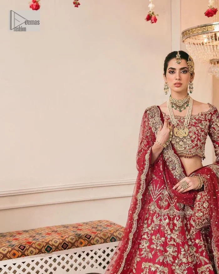 The beauty of this ensemble is mirrored in the romantic colour palette! The blouse is in a dark red shade and is fully decorated with intricate designs and fine details of goldwork. Lavish embroidery, tilla,dabka, kora, Kundan, gold, and zari work make this reception outfit a charismatic masterpiece. The boat shape neckline on a scalloped blouse gives the gorgeous Bride a head-turning look. In addition to this, the three-quarter sleeves for a more upscale appearance and feel. It is systemized with a lehenga in the same colour adorned with heavy floral patterns that are essential for your dreamy look. Complete this romantic look with a dupatta framed with four-sided embellished borders and sequins sprayed all over. Still, thinking? This is a no-brainer. Get your hands on this one ASAP before it sells out!