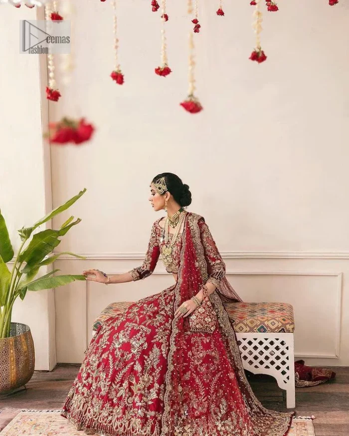 The beauty of this ensemble is mirrored in the romantic colour palette! The blouse is in a dark red shade and is fully decorated with intricate designs and fine details of goldwork. Lavish embroidery, tilla,dabka, kora, Kundan, gold, and zari work make this reception outfit a charismatic masterpiece. The boat shape neckline on a scalloped blouse gives the gorgeous Bride a head-turning look. In addition to this, the three-quarter sleeves for a more upscale appearance and feel. It is systemized with a lehenga in the same colour adorned with heavy floral patterns that are essential for your dreamy look. Complete this romantic look with a dupatta framed with four-sided embellished borders and sequins sprayed all over. Still, thinking? This is a no-brainer. Get your hands on this one ASAP before it sells out!
