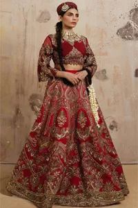 Bold, edgy, and wrapped in glamour. Deep red is the colour of love and affection and the most traditional and desirable colour for the Pakistani bride. DeemasFashion proudly presents a deep red blouse lehenga combo. The exquisitely crafted blouse has intricate zardozi,tilla, dabka, Kundan work and semi-precious stones. The boat shape neckline is embroidered with rich embellishments. Further, the floral patterns on three-quarter sleeves make this outfit unique and lovely. Paired this with a lehenga in the same colour that is heavily adorned with golden embroidery to celebrate your most romantic day. Complete this reception wear with a dupatta in the dark blue colour which is embellished with floral patterns as well. 