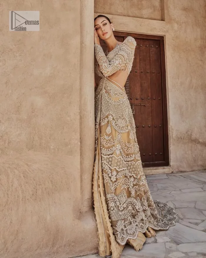 Bold, edgy, and wrapped in glamour. A sumptuous palette of gold with silver delicate embroidery, signature handcrafted embellishment includes tilla, dabka, kora, Kundan, Zardozi and crystals. Take your look to the next level with this golden front open gown which has V shape neckline and full sleeves. The floral patterns on the following gown just steal everyone's heart on your big day. It is paired up with a lehenga to enhance the beauty of this nikah outfit. Complete this article with a dupatta framed with four-sided embellished borders and sequins sprayed all over to wrap you in a bold outfit.