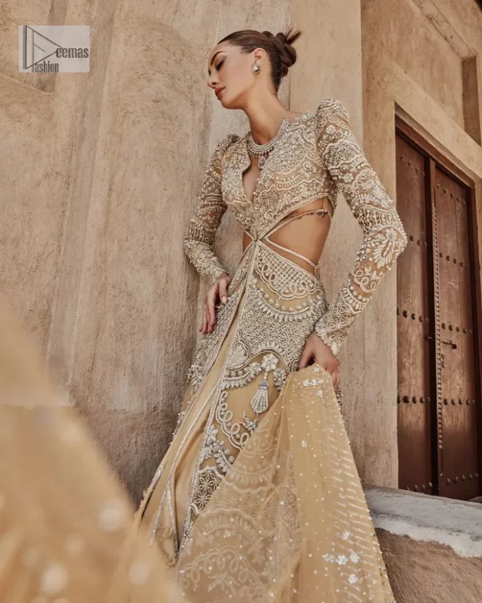 Bold, edgy, and wrapped in glamour. A sumptuous palette of gold with silver delicate embroidery, signature handcrafted embellishment includes tilla, dabka, kora, Kundan, Zardozi and crystals. Take your look to the next level with this golden front open gown which has V shape neckline and full sleeves. The floral patterns on the following gown just steal everyone's heart on your big day. It is paired up with a lehenga to enhance the beauty of this nikah outfit. Complete this article with a dupatta framed with four-sided embellished borders and sequins sprayed all over to wrap you in a bold outfit.