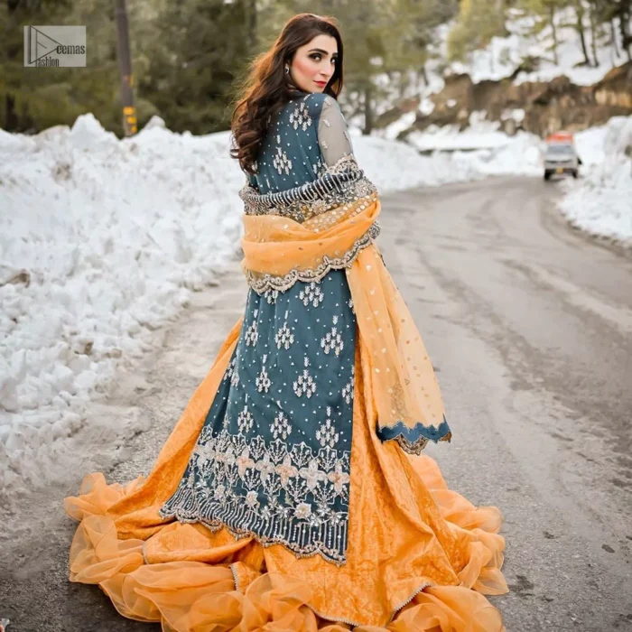 The long shirt is coordinated with an orange lehenga and dupatta. Its comfortable and free-flowing design ensures you move with ease as you revel in the festivities. The bright and lively colour palette adds a playful charm to your attire.