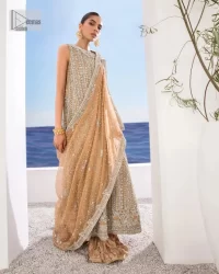 The silver and golden embroidery is the highlight of the party outfit! Keep it dreamy and classic with DeemasFashion. The handsome light orange long shirt is gracefully embellished with silver and gold embroidery that gives you a head-turning appearance on the wedding day. The shirt is enhanced with tilla, dabka, kora, Kundan, and crystals. The round neckline of the shirt makes this glamorous attire an epitome of royalty and grace. It is paired up with crushed sharara to make this masterpiece unique.  A light orange dupatta has a sequin-sprayed surface with branching tiny floral motifs all over. The beautifully embellished border envelopes the dupatta.