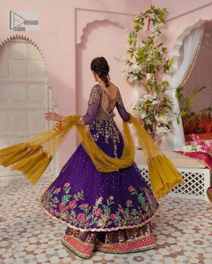 Slay your mehndi looks with signature statement pieces. This stunning plum frock is gracefully emblazoned with tilla, dabka, kora, Kundan, Zardozi and crystal details and graceful multiple-colour embroidery work giving you a breathtaking dreamy appearance at the wedding. The floral motifs on the three-quarter sleeves add grace to the outfit. Further, the round neckline has fine details. It is paired up with a lehenga in the same colour having prominent borders just to prominent you on your Mehndi day. Complete this mehndi outfit with a dupatta with sparkling sequins all over to slay your look.