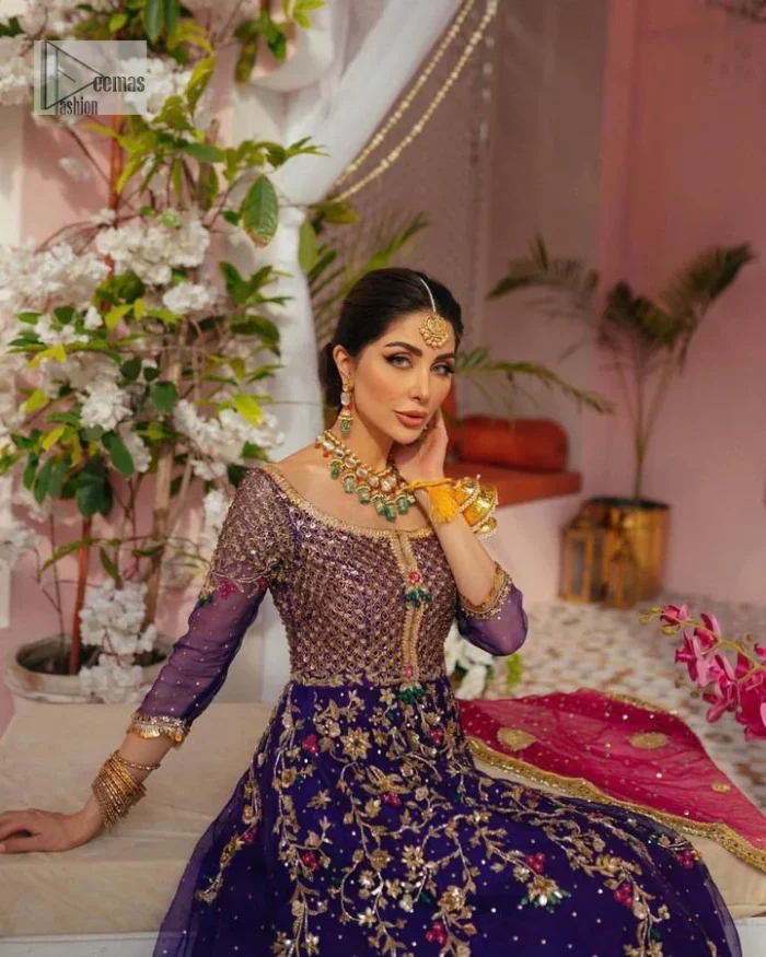 Slay your mehndi looks with signature statement pieces. This stunning plum frock is gracefully emblazoned with tilla, dabka, kora, Kundan, Zardozi and crystal details and graceful multiple-colour embroidery work giving you a breathtaking dreamy appearance at the wedding. The floral motifs on the three-quarter sleeves add grace to the outfit. Further, the round neckline has fine details. It is paired up with a lehenga in the same colour having prominent borders just to prominent you on your Mehndi day. Complete this mehndi outfit with a dupatta with sparkling sequins all over to slay your look.