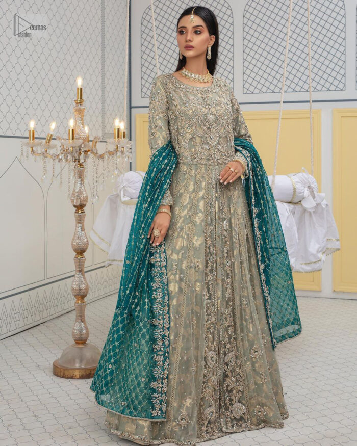 Embellishment is on the rise! The elegant front open maxi is heavily embellished in work of tilla, sequins, dabka, Zardozi, Kundan and kora work. The magnificent maxi is further highlighted with silver embroidery on the front and backside. Further, the full sleeves of the dress come with attractive embellishments. The round neckline makes this masterpiece more unique and charming. This nikah outfit is coordinated with a dupatta in teal green colour framed with a four-sided border and sparkling sequins all over that are on the peak in modern style.