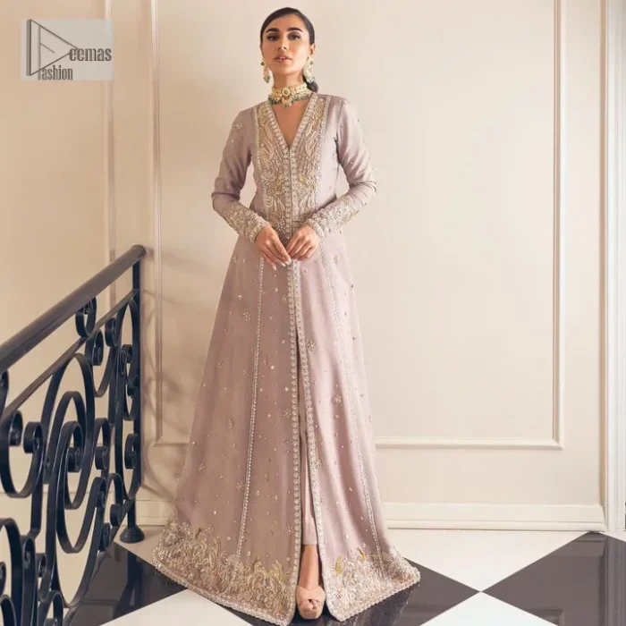 Feel the magic of the party in this splendid article! The ideal front open gown in tea rose colour is heavily hand embellished with floral branches and botanical motifs. It has an embroidered border on the front and back. The V shape neckline is adorned with silver and golden embroidery. It is further prominent with tilla,dabka, kora, Kundan, crystals, stones and the intricate detailing of Zardozi to make this masterpiece lovely and charming. Further, the full sleeves are decorated with tiny floral motifs and sequins spray. It is paired with trousers that complete the party wear look.