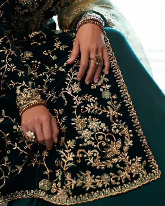 Outfits that define you. DeemasFashion presents the party wear in deep green colour which is adorned with light golden embroidery. It is enhanced with tilla, dabka, kora Kundan and the real magic of Zardozi. The round neckline makes this epitome of beauty. Furthermore, the full sleeves of the front open gown intensify the beauty of the outfit. It is coordinated with a plain lehenga with a border embellished to make you feel fresh and bold at the same time. Complete this attire with a dupatta in ivory colour which is ornamented with a four-sided embellished border to give a royal touch.