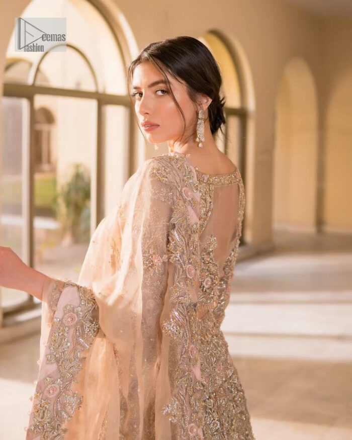 It features a softgalm-inspired look that redefines elegance.  An elegant rhyme to tradition, the attractive and beautiful walima wear lehnga choli creates aesthetical magic with its eye-catching ivory colour. The blouse shines with embellishments and an amalgamation of floral patterns in silver and golden colours. It is further intensified with tilla, dabka, kora, Kundan and the real magic of Zardozi. The boat shape neckline makes this charming. In addition to this, the floral patterns on full sleeves make this masterpiece more lovely. The perfect outfit is paired with a flared lehenga which is heavily ornamented with handsome embroidery. Complete this with an organza dupatta which is adorned with a four-sided embellished border and sprayed with tiny floral motifs and sequins all over to make your day fresh and bright.