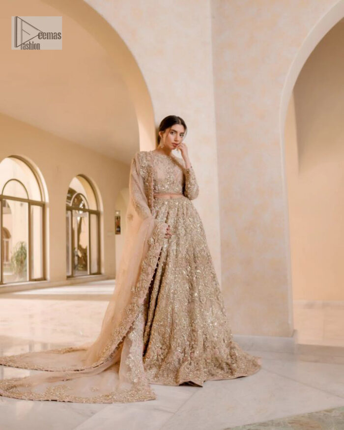 It features a softgalm-inspired look that redefines elegance.  An elegant rhyme to tradition, the attractive and beautiful walima wear lehnga choli creates aesthetical magic with its eye-catching ivory colour. The blouse shines with embellishments and an amalgamation of floral patterns in silver and golden colours. It is further intensified with tilla, dabka, kora, Kundan and the real magic of Zardozi. The boat shape neckline makes this charming. In addition to this, the floral patterns on full sleeves make this masterpiece more lovely. The perfect outfit is paired with a flared lehenga which is heavily ornamented with handsome embroidery. Complete this with an organza dupatta which is adorned with a four-sided embellished border and sprayed with tiny floral motifs and sequins all over to make your day fresh and bright.