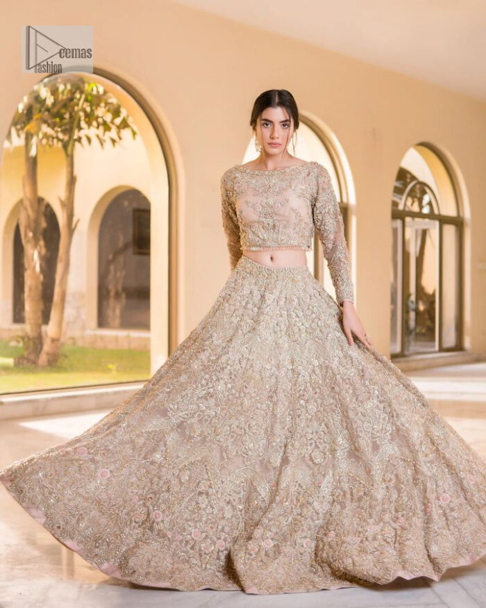 It features a softgalm-inspired look that redefines elegance.  An elegant rhyme to tradition, the attractive and beautiful walima wear lehnga choli creates aesthetical magic with its eye-catching ivory colour. The blouse shines with embellishments and an amalgamation of floral patterns in silver and golden colours. It is further intensified with tilla, dabka, kora, Kundan and the real magic of Zardozi. The boat shape neckline makes this charming. In addition to this, the floral patterns on full sleeves make this masterpiece more lovely. The perfect outfit is paired with a flared lehenga which is heavily ornamented with handsome embroidery. Complete this with an organza dupatta which is adorned with a four-sided embellished border and sprayed with tiny floral motifs and sequins all over to make your day fresh and bright.
