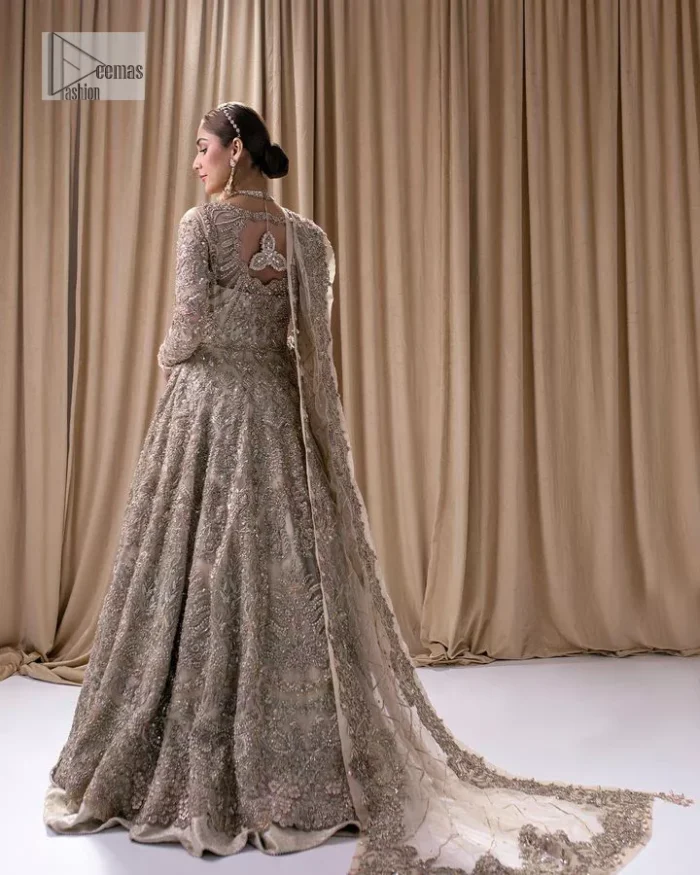Make a statement with a light fawn article on your nikah day! DeemasFashion presents the light fawn heavy maxi which is embellished with silver embroidery using dabka, tilla, kora, Zardozi, Swarovski, Mukesh, sequin and Kundan. The strap neckline adds a little romanticness to the dress. Further, the floral patterns on full sleeves make this masterpiece modern and unique. It is paired with a  lehenga, embellished with a delicate border. It is styled with a dupatta; its surface is sprayed with sequin and the dupatta is enveloped by a heavily embellished floral border.