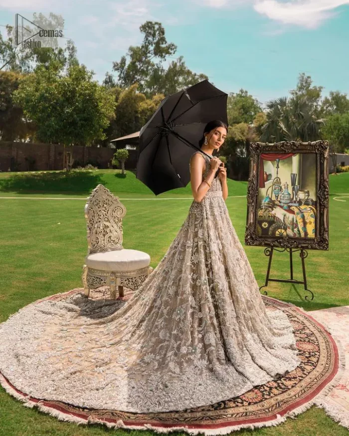 Your wedding vibe. Your wedding mood. Your wedding scent. The light fawn back train heavy maxi and dupatta are hand embellished with straight tilla, dabka, Kundan, Zardozi and kora with running hangings of pearls, crystals, and flat sequins. The sleeveless style of the following back train maxi gives a romantic touch to the whole walima wear. Further, the jewel neckline makes this symbol of beauty. It is paired up with a dupatta framed with a four-sided embellished border with our statement floral pattern and sprayed sequins to make you feel fresh and bold.