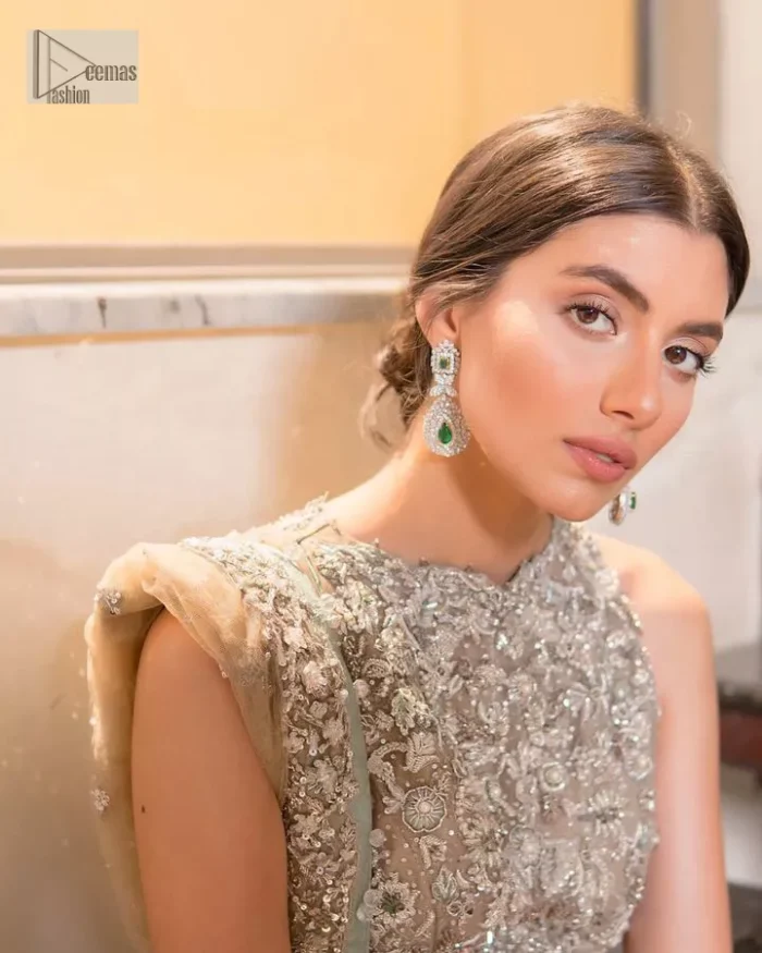 Your wedding vibe. Your wedding mood. Your wedding scent. The light fawn back train heavy maxi and dupatta are hand embellished with straight tilla, dabka, Kundan, Zardozi and kora with running hangings of pearls, crystals, and flat sequins. The sleeveless style of the following back train maxi gives a romantic touch to the whole walima wear. Further, the jewel neckline makes this symbol of beauty. It is paired up with a dupatta framed with a four-sided embellished border with our statement floral pattern and sprayed sequins to make you feel fresh and bold.