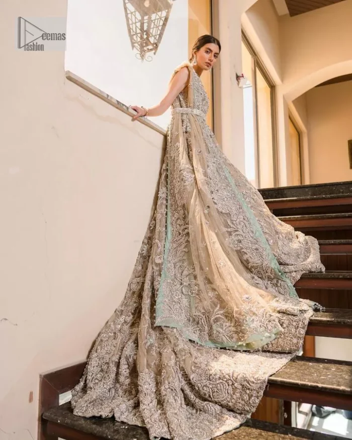 Your wedding vibe. Your wedding mood. Your wedding scent. The light fawn back train heavy maxi and dupatta are hand embellished with straight tilla, dabka, Kundan, Zardozi and kora with running hangings of pearls, crystals, and flat sequins. The sleeveless style of the following back train maxi gives a romantic touch to the whole walima wear. Further, the jewel neckline makes this symbol of beauty. It is paired up with a dupatta framed with a four-sided embellished border with our statement floral pattern and sprayed sequins to make you feel fresh and bold.