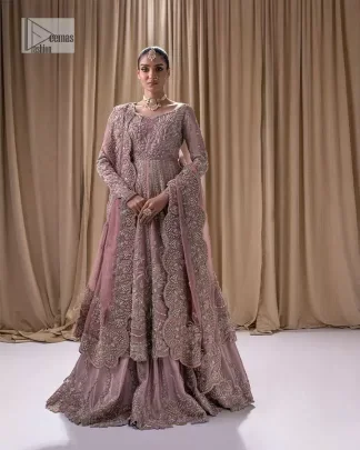 Stand out and stay pink with this nikah wear! The delightful article in pink colour is a traditional masterpiece that will give the gorgeous bride a head-turning look at the wedding. The frock has a sweetheart neckline to make this outfit lovely. It is adorned with silver and golden embroidery which is magnified with tilla, dabka, Koran, Kundan and the details of Zardozi. Further, the combination of tiny and large floral motifs on full sleeves provides a perfect finishing look to this masterpiece. It is paired up with a lehenga in the same colour making it an epitome of beauty and grace. Finish this with a dupatta framed with four-sided embellished scalloped borders and tiny floral motifs all over.
