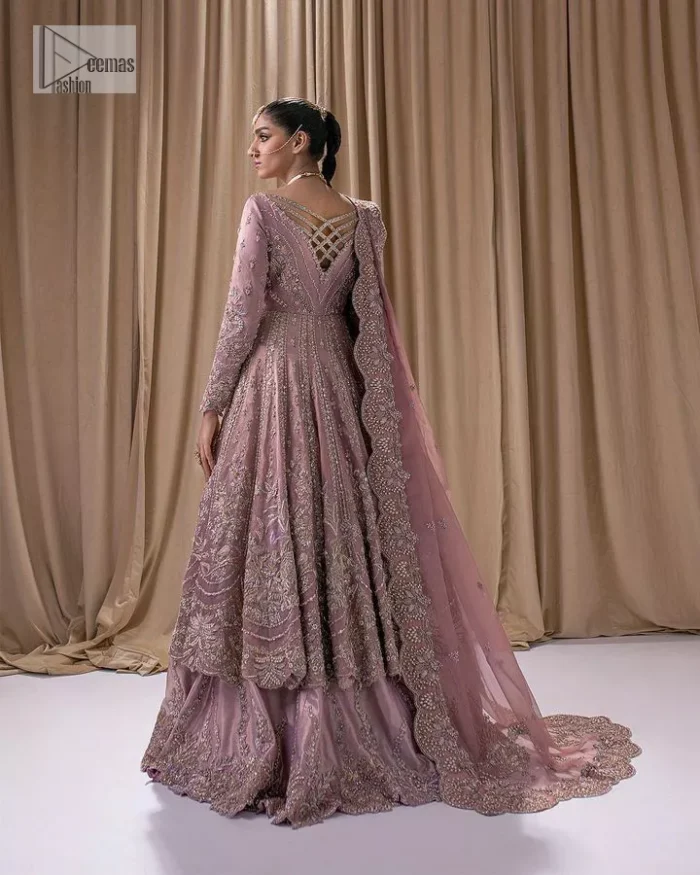 Stand out and stay pink with this nikah wear! The delightful article in pink colour is a traditional masterpiece that will give the gorgeous bride a head-turning look at the wedding. The frock has a sweetheart neckline to make this outfit lovely. It is adorned with silver and golden embroidery which is magnified with tilla, dabka, Koran, Kundan and the details of Zardozi. Further, the combination of tiny and large floral motifs on full sleeves provides a perfect finishing look to this masterpiece. It is paired up with a lehenga in the same colour making it an epitome of beauty and grace. Finish this with a dupatta framed with four-sided embellished scalloped borders and tiny floral motifs all over.