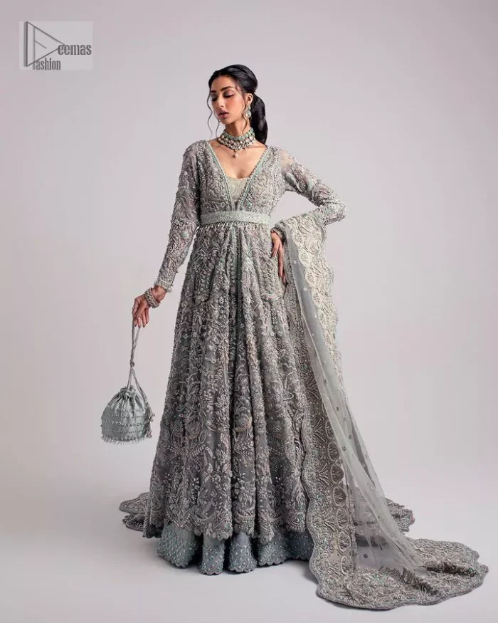 The beautiful mint green reception wear is a breathtaking masterpiece that will give you a magnificent look at the wedding. Lavish embroidery work and hand-crafted embellishments provide a perfect finishing look to this pishwas. It is adorned with silver embroidery which involves tilla, dabka, kora, Kundan and the real magic of zardozi. Further, the V shape neckline makes this masterpiece unique and attractive. The full sleeves are full of floral embroidery patterns. It is paired up with a lehenga with embroidered border to balance the outfit's look. The dress achieves the final elegant look when paired with a delicate dupatta embellished with four-sided scalloped edges and tiny floral motifs all over.