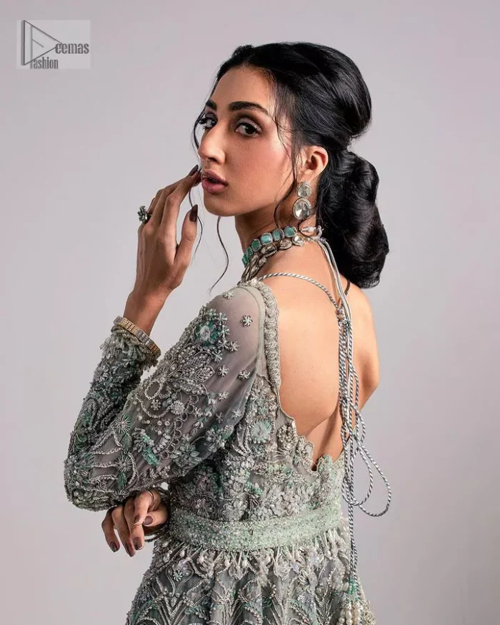 The beautiful mint green reception wear is a breathtaking masterpiece that will give you a magnificent look at the wedding. Lavish embroidery work and hand-crafted embellishments provide a perfect finishing look to this pishwas. It is adorned with silver embroidery which involves tilla, dabka, kora, Kundan and the real magic of zardozi. Further, the V shape neckline makes this masterpiece unique and attractive. The full sleeves are full of floral embroidery patterns. It is paired up with a lehenga with embroidered border to balance the outfit's look. The dress achieves the final elegant look when paired with a delicate dupatta embellished with four-sided scalloped edges and tiny floral motifs all over.