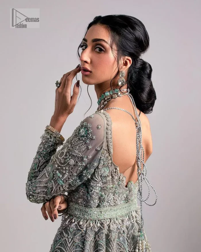 The beautiful mint green reception wear is a breathtaking masterpiece that will give you a magnificent look at the wedding. Lavish embroidery work and hand-crafted embellishments provide a perfect finishing look to this pishwas. It is adorned with silver embroidery which involves tilla, dabka, kora, Kundan and the real magic of zardozi. Further, the V shape neckline makes this masterpiece unique and attractive. The full sleeves are full of floral embroidery patterns. It is paired up with a lehenga with embroidered border to balance the outfit's look. The dress achieves the final elegant look when paired with a delicate dupatta embellished with four-sided scalloped edges and tiny floral motifs all over.