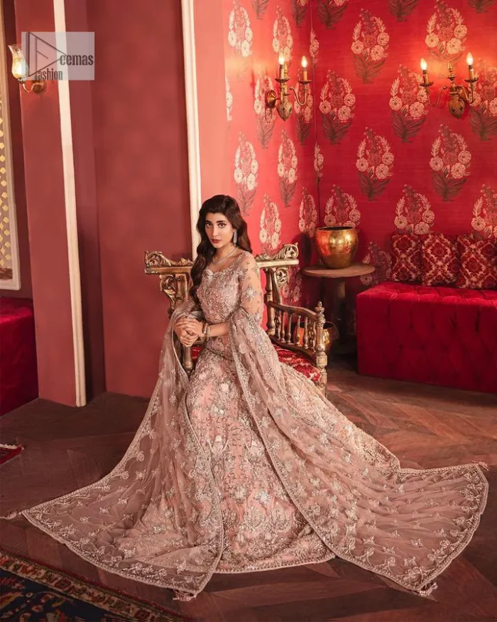 The beautiful outfit comes has an alluring peach colour and is gracefully emblazoned with embroidery. Hand-crafted details of tilla, dabka, kora, Kundan, stones, motifs, and sequins enhance the charm of this outfit. The sweetheart neckline makes this blouse a little more romantic for your walima day. Further, the floral motifs on half sleeves are just a new trend of looming on your day. It is organized with a heavy lehenga. Beaming silver work, floral designs, and lavish details give a perfect finishing look to the masterpiece. Complete this attire with a dupatta framed with a four-sided borders and floral motifs all over.
