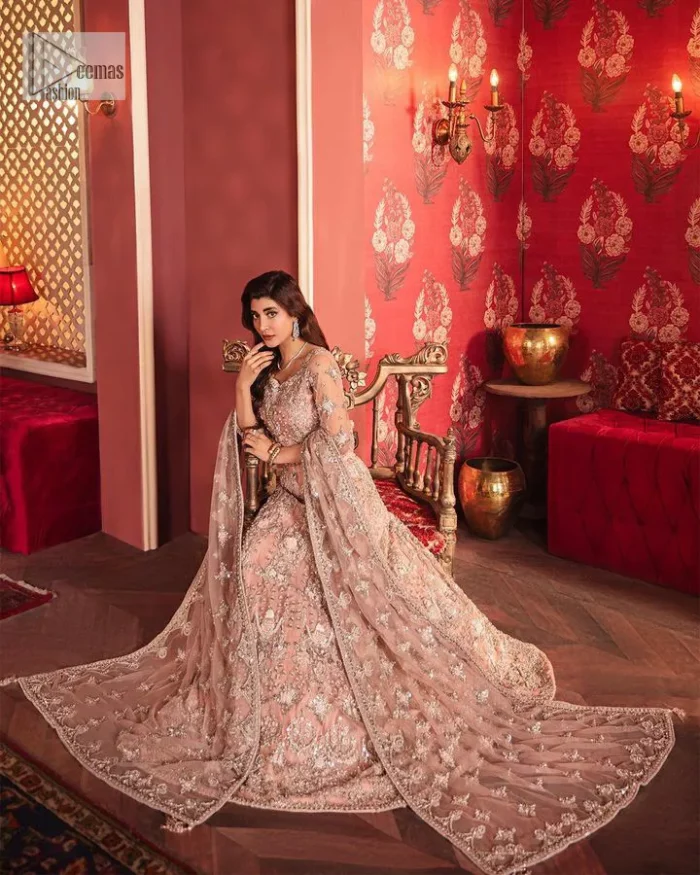 The beautiful outfit comes has an alluring peach colour and is gracefully emblazoned with embroidery. Hand-crafted details of tilla, dabka, kora, Kundan, stones, motifs, and sequins enhance the charm of this outfit. The sweetheart neckline makes this blouse a little more romantic for your walima day. Further, the floral motifs on half sleeves are just a new trend of looming on your day. It is organized with a heavy lehenga. Beaming silver work, floral designs, and lavish details give a perfect finishing look to the masterpiece. Complete this attire with a dupatta framed with a four-sided borders and floral motifs all over.