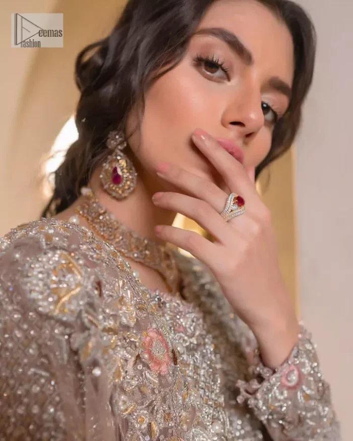 Let your nikah outfit do the talking.  An elegant rhyme to tradition, this short shirt and lehenga create aesthetical magic with its eye-catching hues of rose pink. The beautiful article shines with silver embellishments and an amalgamation of floral patterns which is enhanced with tilla, dabka, kora, Kundan and the detailing of Zardozi.  The full sleeves are heavily embroidered with floral patterns. Further, the V shape neckline makes this epitome of beauty. The lehenga is also intensified with beautiful embroidery. The perfect opulent short-shirt lehenga outfit is paired with an organza dupatta which is adorned with a four-sided embellished border and sequins sprayed all over