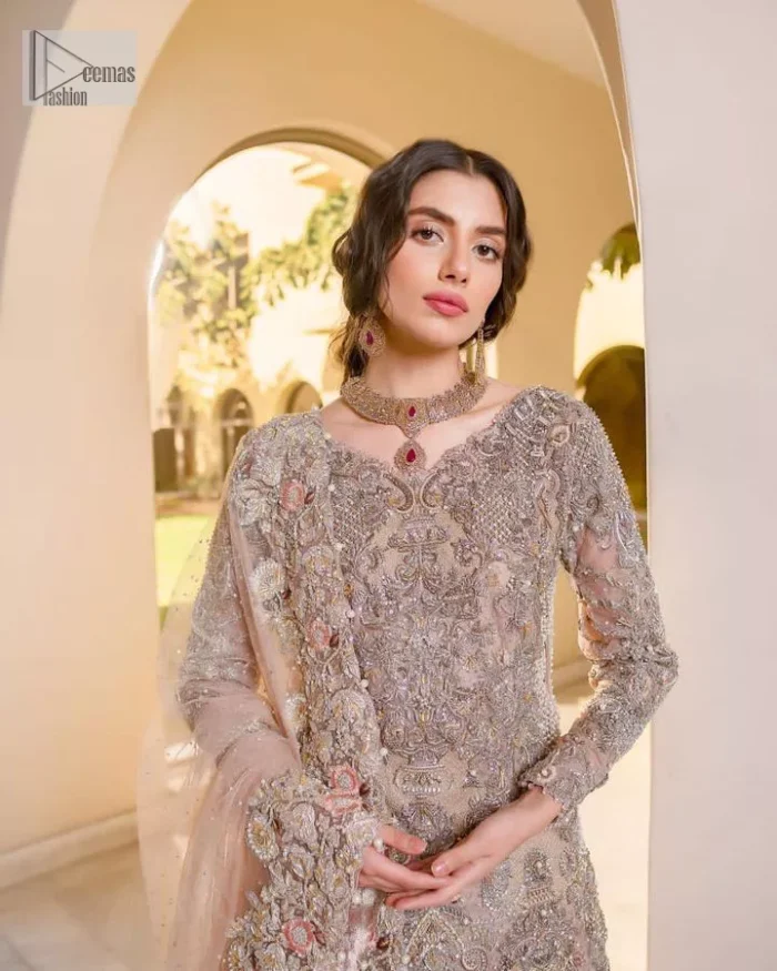 Let your nikah outfit do the talking.  An elegant rhyme to tradition, this short shirt and lehenga create aesthetical magic with its eye-catching hues of rose pink. The beautiful article shines with silver embellishments and an amalgamation of floral patterns which is enhanced with tilla, dabka, kora, Kundan and the detailing of Zardozi.  The full sleeves are heavily embroidered with floral patterns. Further, the V shape neckline makes this epitome of beauty. The lehenga is also intensified with beautiful embroidery. The perfect opulent short-shirt lehenga outfit is paired with an organza dupatta which is adorned with a four-sided embellished border and sequins sprayed all over