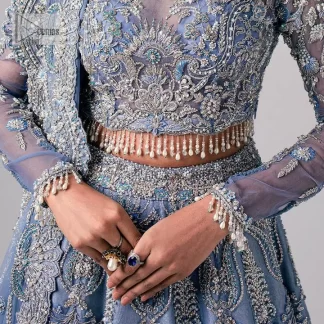 Stay blue and look your best! A sky blue lehenga choli is hand embellished with floral patterns and botanical motifs. The blouse is encrusted with silver embroidery which is enhanced with tilla, dabka, kora, Kundan and the real magic of Zardozi. The jewel neckline and full sleeves make this masterpiece lovely and charming. It is paired up with a lehenga in the same colour that has embellished on the front and back finish. Complete the walima wear with a dupatta having four-sided Kiran and tiny floral motifs all over just to complete the look.