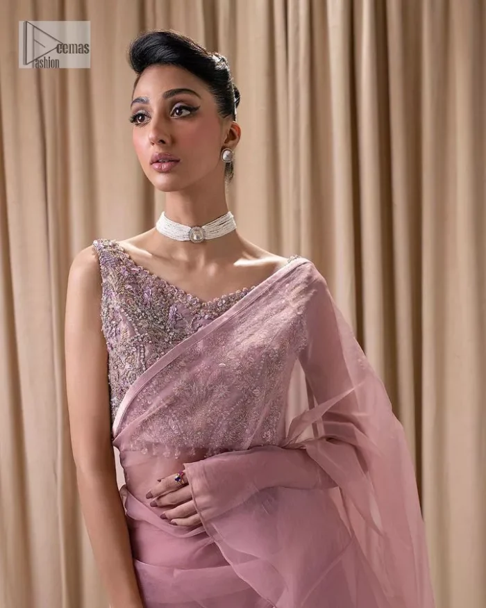Turn heads in our stunning bridesmaid saree! The beautiful tea pink blouse is adorned with silver and golden embroidery which is intensified with tilla, dabka, kora, Kundan and the details of Zardozi. The V shape neckline provides a perfect finishing look to this masterpiece. In addition to this, the sleeveless style of the following blouse makes this outfit unique and romantic. It is paired up with a frilled saree which is plain just to enhance the beauty of this lovely outfit. 