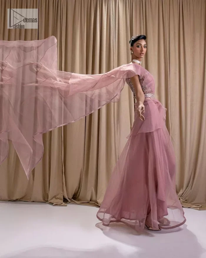 Turn heads in our stunning bridesmaid saree! The beautiful tea pink blouse is adorned with silver and golden embroidery which is intensified with tilla, dabka, kora, Kundan and the details of Zardozi. The V shape neckline provides a perfect finishing look to this masterpiece. In addition to this, the sleeveless style of the following blouse makes this outfit unique and romantic. It is paired up with a frilled saree which is plain just to enhance the beauty of this lovely outfit. 