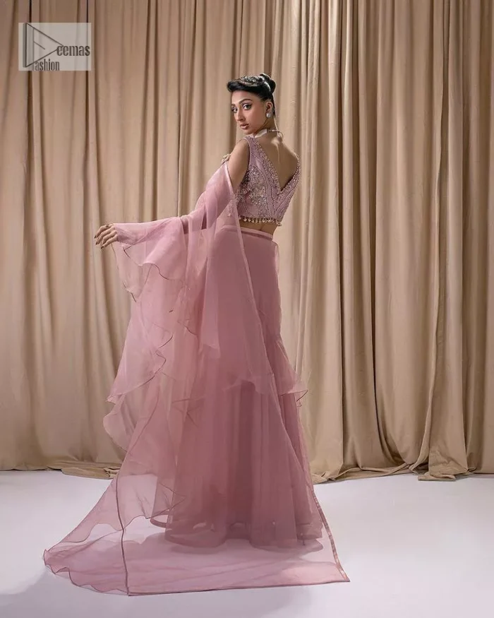 Turn heads in our stunning bridesmaid saree! The beautiful tea pink blouse is adorned with silver and golden embroidery which is intensified with tilla, dabka, kora, Kundan and the details of Zardozi. The V shape neckline provides a perfect finishing look to this masterpiece. In addition to this, the sleeveless style of the following blouse makes this outfit unique and romantic. It is paired up with a frilled saree which is plain just to enhance the beauty of this lovely outfit. 