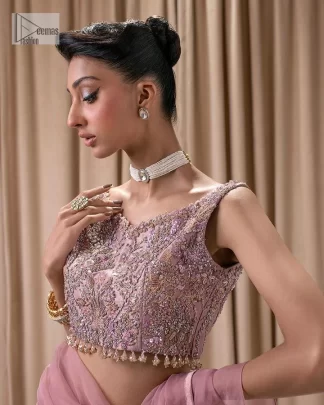 Turn heads in our stunning bridesmaid saree! The beautiful tea pink blouse is adorned with silver and golden embroidery which is intensified with tilla, dabka, kora, Kundan and the details of Zardozi. The V shape neckline provides a perfect finishing look to this masterpiece. In addition to this, the sleeveless style of the following blouse makes this outfit unique and romantic. It is paired up with a frilled saree which is plain just to enhance the beauty of this lovely outfit. 