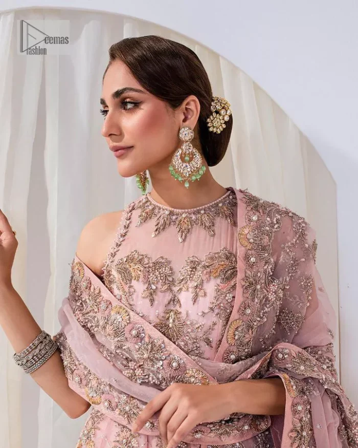 Matching embellishments are here to stay. The attractive tea pink nikah article is a stunning attire adorned with tilla, dabka, kora, Kundan, Zardozi and Gota.  Hand-crafted embellishments of golden and silver embroidery and floral patterns give a perfect finishing look to the maxi. The following scalloped maxi has a jewel neckline to make this unique and charming. In addition to this, the sleeveless style of the maxi is a breathtaking masterpiece that will give the gorgeous bride a breathtaking traditional look at the wedding. It is paired up with a plain lehenga to balance the astonishing look. Finish this with a dupatta that has four-sided embellished borders and tiny floral motifs all over to make your day glow and flowery.