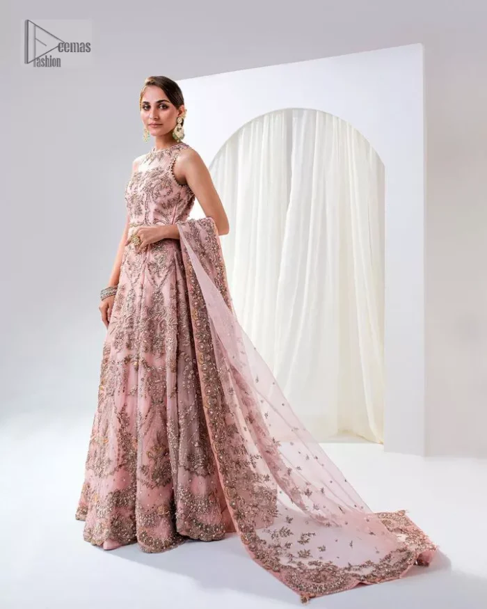 Matching embellishments are here to stay. The attractive tea pink nikah article is a stunning attire adorned with tilla, dabka, kora, Kundan, Zardozi and Gota.  Hand-crafted embellishments of golden and silver embroidery and floral patterns give a perfect finishing look to the maxi. The following scalloped maxi has a jewel neckline to make this unique and charming. In addition to this, the sleeveless style of the maxi is a breathtaking masterpiece that will give the gorgeous bride a breathtaking traditional look at the wedding. It is paired up with a plain lehenga to balance the astonishing look. Finish this with a dupatta that has four-sided embellished borders and tiny floral motifs all over to make your day glow and flowery.