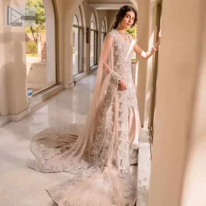 The beauty of idealism is captured with a touch of sparkle. This exclusive rose pink ensemble is beautifully translated on rose pink canvas, which makes this walima outfit stand out in the crowd. This fully embellished article comes with a short shirt lehenga style that gives it a bold look. The round neckline makes this masterpiece a unique cut. The short shirt is adorned with a silver embroidery which involves tilla, dabka, kora, Kundan and the real magic of Zardozi. Further, the sleeveless style of the following short shirt adds charm to the lehenga with heavy border embellishments on it. Carrying out its final contemporary look with a net scalloped dupatta framed with four-sided embellished borders and cross lines all over.
