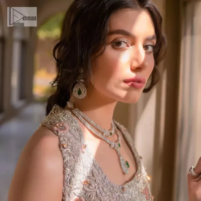 The beauty of idealism is captured with a touch of sparkle. This exclusive rose pink ensemble is beautifully translated on rose pink canvas, which makes this walima outfit stand out in the crowd. This fully embellished article comes with a short shirt lehenga style that gives it a bold look. The round neckline makes this masterpiece a unique cut. The short shirt is adorned with a silver embroidery which involves tilla, dabka, kora, Kundan and the real magic of Zardozi. Further, the sleeveless style of the following short shirt adds charm to the lehenga with heavy border embellishments on it. Carrying out its final contemporary look with a net scalloped dupatta framed with four-sided embellished borders and cross lines all over.