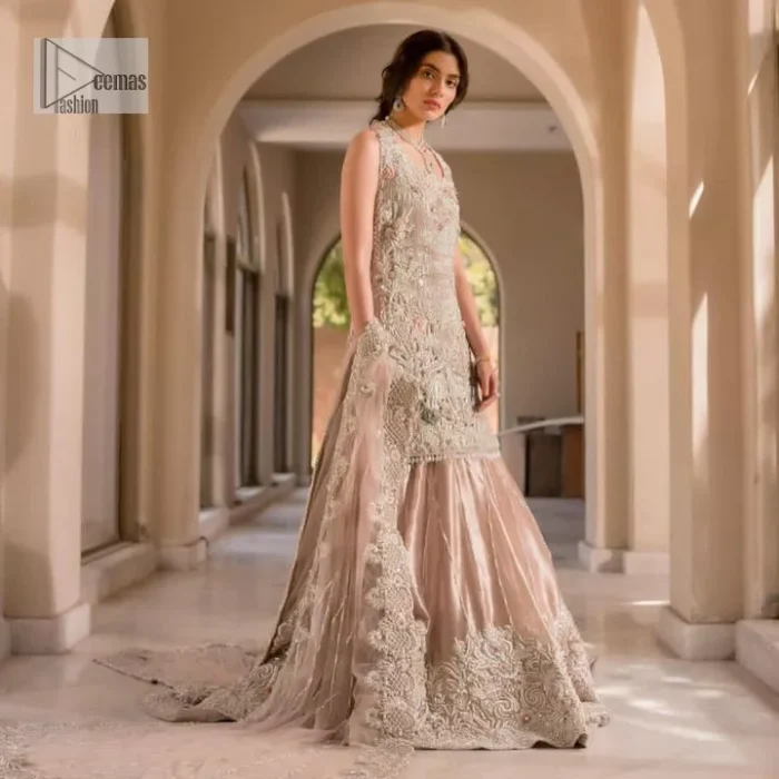 The beauty of idealism is captured with a touch of sparkle. This exclusive rose pink ensemble is beautifully translated on rose pink canvas, which makes this walima outfit stand out in the crowd. This fully embellished article comes with a short shirt lehenga style that gives it a bold look. The round neckline makes this masterpiece a unique cut. The short shirt is adorned with a silver embroidery which involves tilla, dabka, kora, Kundan and the real magic of Zardozi. Further, the sleeveless style of the following short shirt adds charm to the lehenga with heavy border embellishments on it. Carrying out its final contemporary look with a net scalloped dupatta framed with four-sided embellished borders and cross lines all over.