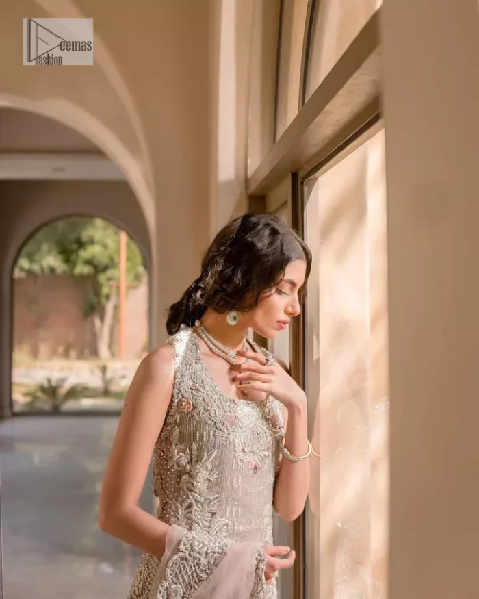 The beauty of idealism is captured with a touch of sparkle. This exclusive rose pink ensemble is beautifully translated on rose pink canvas, which makes this walima outfit stand out in the crowd. This fully embellished article comes with a short shirt lehenga style that gives it a bold look. The round neckline makes this masterpiece a unique cut. The short shirt is adorned with a silver embroidery which involves tilla, dabka, kora, Kundan and the real magic of Zardozi. Further, the sleeveless style of the following short shirt adds charm to the lehenga with heavy border embellishments on it. Carrying out its final contemporary look with a net scalloped dupatta framed with four-sided embellished borders and cross lines all over.