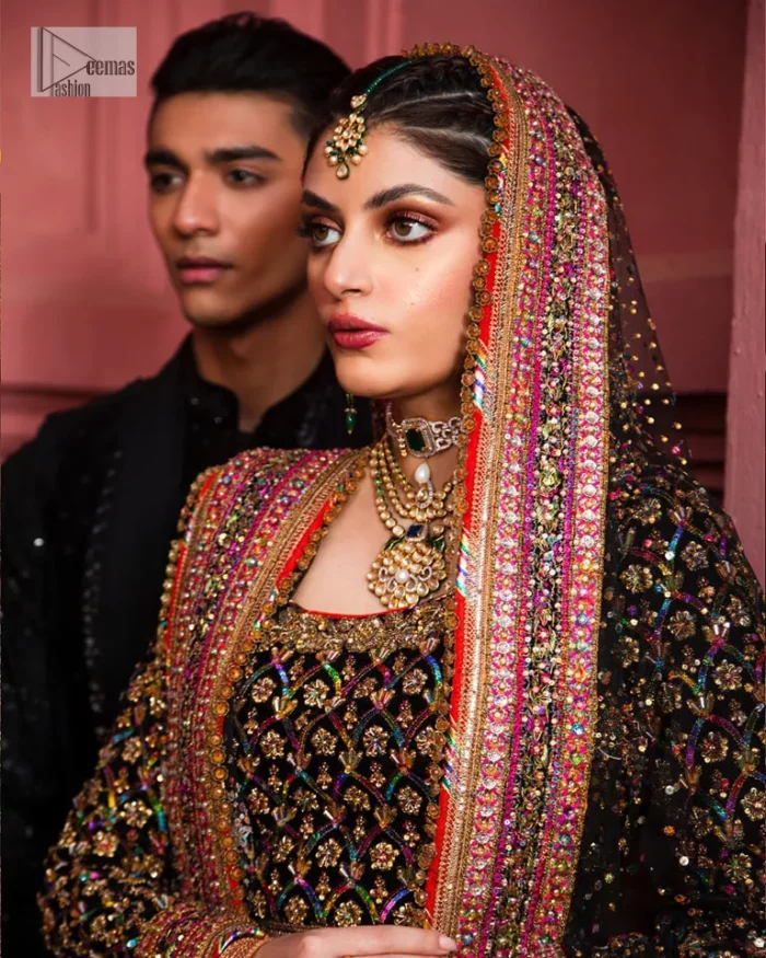 Make your superb days bright and bold! A jet black blouse with floral branches, peacock motifs and Mughal-inspired embellishments with dabka, naqshi, cut dana, Resham, Swarovski, Zardozi, tilla and Kundan. It is supported with a round neckline and full sleeves to make this masterpiece a traditional look. The lehenga has an embellished border around its flare that is complemented and decorated with multiple colour embroidery. It is paired with an organza dupatta in the same colour with a sequin-sprayed surface and intricately embellished borders on all sides.