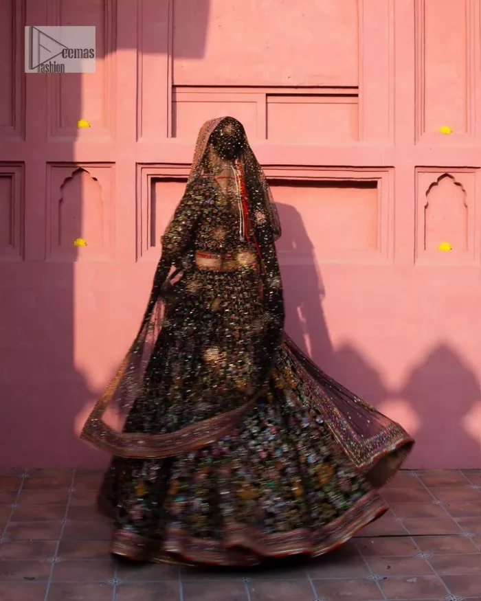 Make your superb days bright and bold! A jet black blouse with floral branches, peacock motifs and Mughal-inspired embellishments with dabka, naqshi, cut dana, Resham, Swarovski, Zardozi, tilla and Kundan. It is supported with a round neckline and full sleeves to make this masterpiece a traditional look. The lehenga has an embellished border around its flare that is complemented and decorated with multiple colour embroidery. It is paired with an organza dupatta in the same colour with a sequin-sprayed surface and intricately embellished borders on all sides.