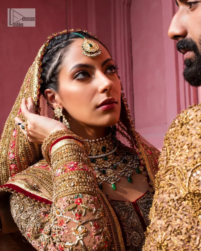 Create a look that’s for you with just one twist of this reception wear. A soft brown short shirt heavily embellished with tilla, dabka, Kora, Zardozi and Kundan. This beautiful dress has Mughal-inspired motifs, geometrical patterns, floral motifs and appliquéd silks. The round neckline makes this masterpiece unique and lovely. In addition to this, the full sleeves also admire its beauty. A lehenga supports it with an embellished border. The organza dupatta has a sequin-sprayed surface with branching floral motifs and it is enveloped with four-sided beautiful borders.
