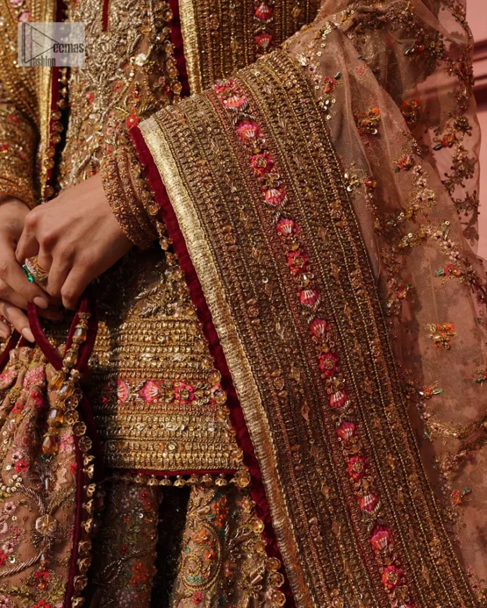 Create a look that’s for you with just one twist of this reception wear. A soft brown short shirt heavily embellished with tilla, dabka, Kora, Zardozi and Kundan. This beautiful dress has Mughal-inspired motifs, geometrical patterns, floral motifs and appliquéd silks. The round neckline makes this masterpiece unique and lovely. In addition to this, the full sleeves also admire its beauty. A lehenga supports it with an embellished border. The organza dupatta has a sequin-sprayed surface with branching floral motifs and it is enveloped with four-sided beautiful borders.