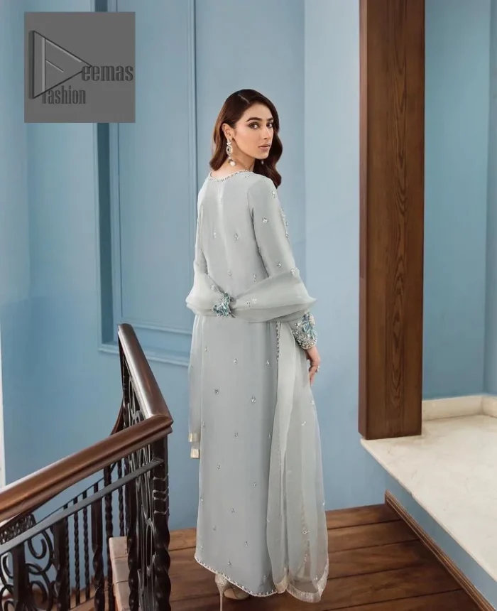 Timeless details that add an extra edge to your looks! Deemas Fashion presents this Party outfit, an embellished masterpiece that wins everyone’s hearts at first glance with its charm and elegance. The shirt in the Gray colour is laden with golden and teal embroidery, making this attire a head-turning masterpiece. Further, the round neckline is fully embellished with tilla, dabka, kora, Kundan, and pearls that give it a magical look. The full-sleeved style makes this outfit a little attractive but super charming. Complete this article with a dupatta, having a tiny floral motif all over to give you a decent look.