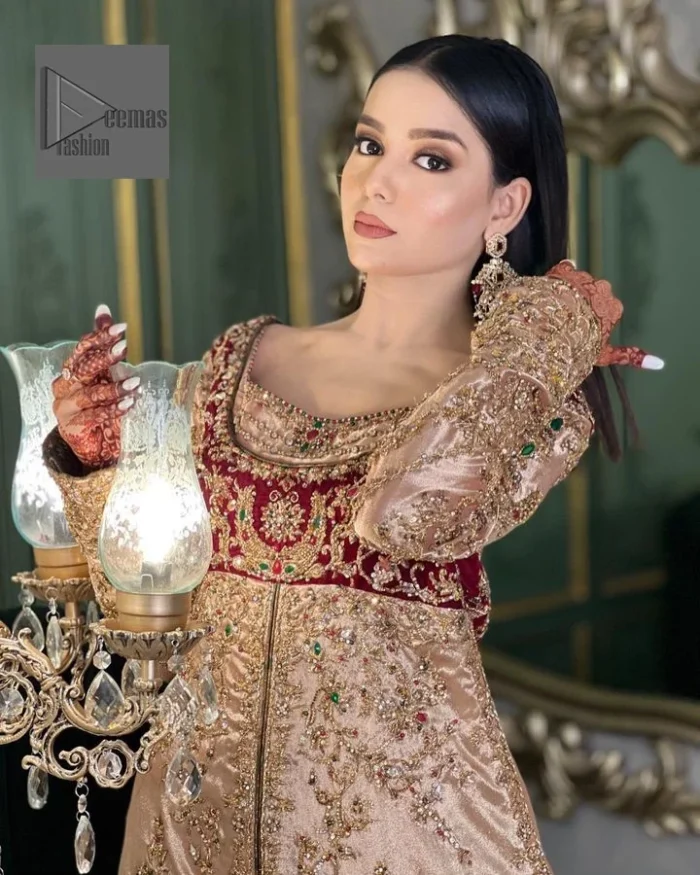 Your words about your special day is expertly written in this beautiful dress. This ivory front open gown is the picture of elegance and majesty. Silver dabka, pearls, tilla, kora, Kundan, zardozi, and the true magic of beads are used to embellish the stunning garment. Golden embroidery on it makes it stand out. The V-shaped neckline of the dress elevates this ensemble. Moreover, full sleeves are embellished with the lovely embroidery. Pairing the richly embroidered ivory gown with a set of simple frilled lehenga and inner frock would look stunning. To achieve professional magic, it is set up with a dupatta that is bordered with four-sided borders and spray of sequins all over.