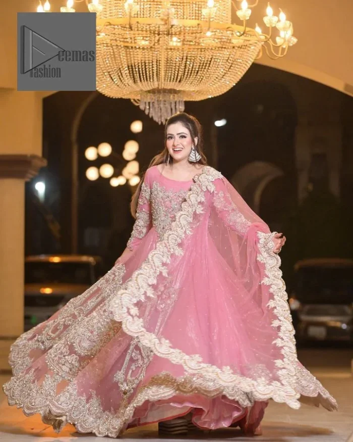 DeemasFashion presents this wedding outfit which is an embellished masterpiece that wins everyone’s hearts at the very first glance with its charm and elegance. The Maxi in the Pink colour has laden with Golden embroidery which makes this attire a head-turning masterpiece. Further, the round neckline is fully embellished with tilla, dabka, kora, Kundan, and pearls that is giving it a magical look. The fullsleeves style makes this outfit a little attractive but super charming. Complete this article with a dupatta, framed with a four-sided border.