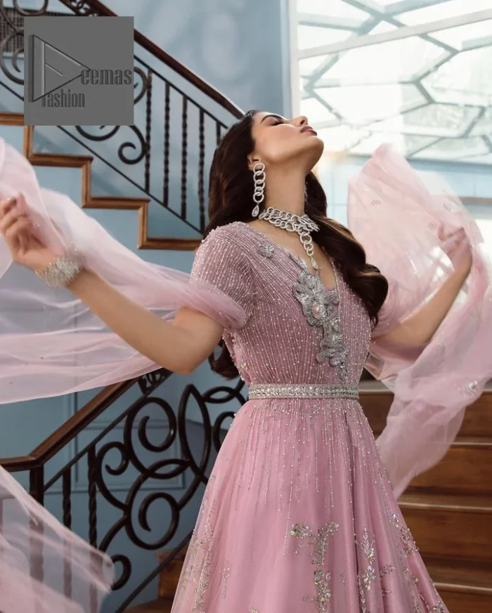 DeemasFashion presents this wedding outfit which is an embellished masterpiece that wins everyone’s hearts at the very first glance with its charm and elegance. The Maxi in the Pink colour has laden with Silver embroidery which makes this attire a head-turning masterpiece. Further, the v-neckline is fully embellished with tilla, dabka, kora, Kundan, and pearls that is giving it a magical look. The hanging sleeves style makes this outfit a little attractive but super charming. Complete this article with a dupatta, framed with a four-sided border.