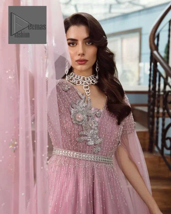 DeemasFashion presents this wedding outfit which is an embellished masterpiece that wins everyone’s hearts at the very first glance with its charm and elegance. The Maxi in the Pink colour has laden with Silver embroidery which makes this attire a head-turning masterpiece. Further, the v-neckline is fully embellished with tilla, dabka, kora, Kundan, and pearls that is giving it a magical look. The hanging sleeves style makes this outfit a little attractive but super charming. Complete this article with a dupatta, framed with a four-sided border.